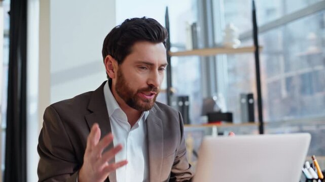 Dissatisfied manager quarrelling web chat gesturing to laptop in office closeup.