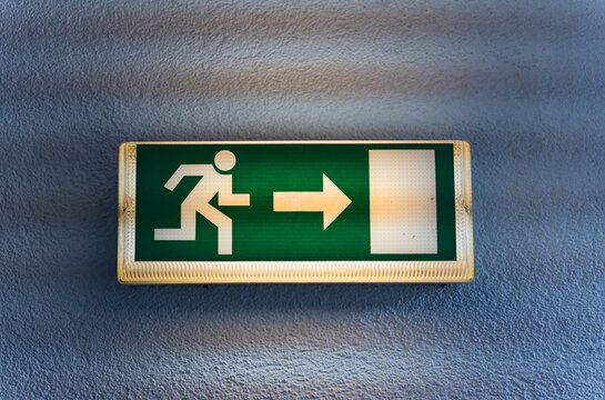 Emergency exit sign with person and arrow pointing right