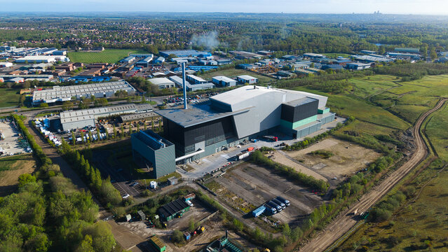 Aerial view of the Energy Recovery Facility featuring modern industrial architecture and a tall chimney surrounded by green fields and urban landscape in Lincoln, England, United Kingdom.