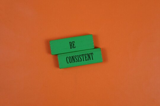 Be Consistent Message On Green Blocks Over Orange Background For Motivation And Productivity