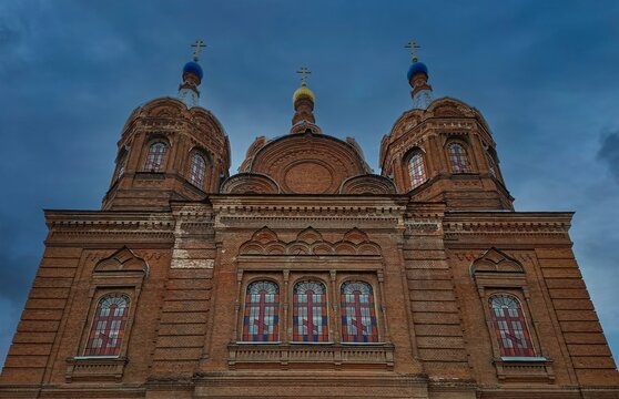 Low angle view of the red brick Russian Orthodox Church of the Yelets Icon of the Mother of God against a blue sky