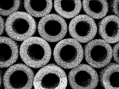 Industrial dark abstract view of cylindrical shapes arranged in a pattern showing depth and repetition in lines