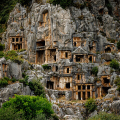 Fototapeta premium Ancient Lycian rock tombs carved into a mountain cliff side