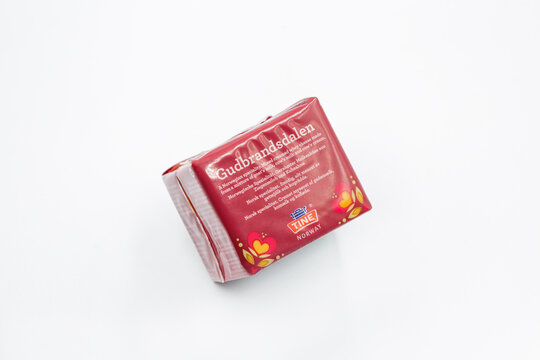Gudbrandsdalen Norwegian brown caramel cheese block packaging closeup on white.