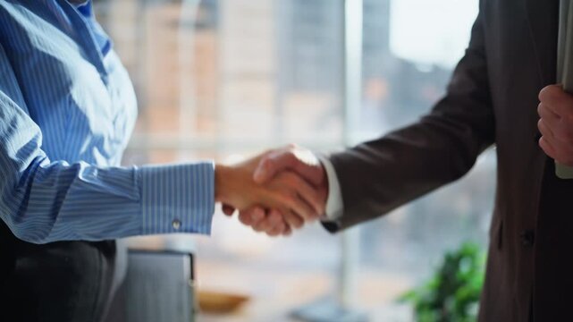 Closeup business people shaking hands at successful meeting standing office.