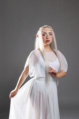 Fototapeta premium Beautiful girl dressed as elf on grey background