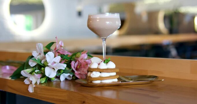 beautiful breakfast, dessert with airy white cream, coffee drink, white and pink orchid flowers in glass on wooden table, a wonderful dessert in a luxury restaurant, relaxation, pleasure, wealth.