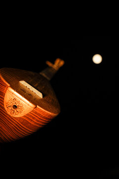 Artistic close-up of traditional Turkish baglama saz instrument with fullmoon