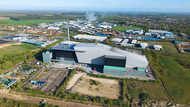 Aerial view of the Energy Recovery Facility with its modern architecture and tall chimney stack surrounded by industrial buildings and green fields Lincoln, England, United Kingdom.