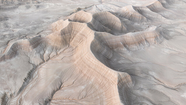 Aerial View of Arid Desert Badlands with Textured Sands and Eroded Hills