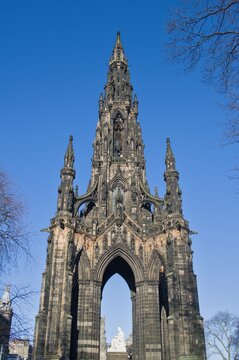 The Scott Monument's Gothic spire and arches photographed against a vivid blue sky in Edinburgh, Scotland.