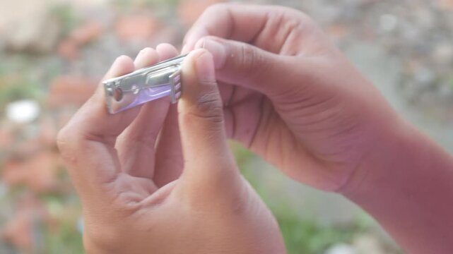 a man is cutting his fingernails using a metal nail clipper