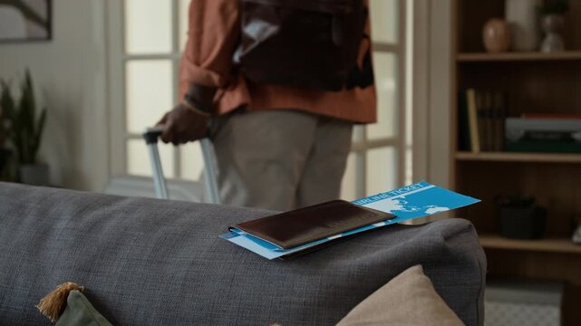 Midsection shot of unrecognizable careless couple with suitcases departing for summer holiday abroad, leaving behind tickets and passports, man remembering and returning for documents