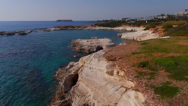 Wide Aerial View of Dramatic White Cliffs and Rugged Coastline Towards Geronisos Island Cyprus