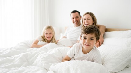 Obraz premium happy family mother, father and children laughing, playing and tickles in bed at home. 