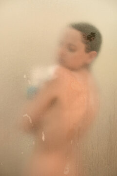 Young woman in a shower behind glass