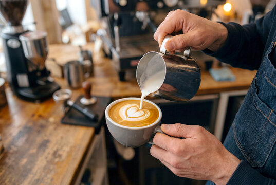 カフェでラテアートを仕上げるバリスタ