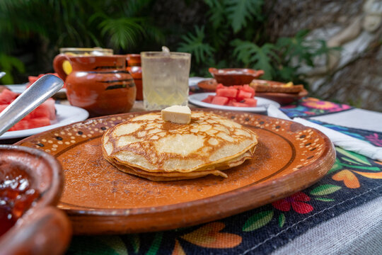 desayuno mexicano, en mesa con mantel, jugos y fruta, juego, frijoles y pan