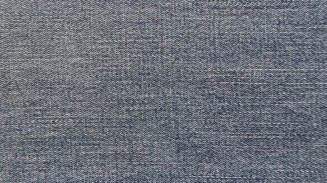 Static flat lay of medium blue denim fabric showing detailed texture and weave. Ideal as a background for fashion, textile, and design concepts.