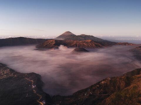 Aerial view of the volcanic peaks of Bromo Tengger Semeru National Park rising above a thick sea of mist at sunrise Bromo, East Java, Indonesia.