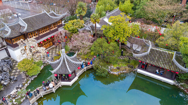 Aerial view of Lan Su Chinese Garden with traditional pavilions, stone bridges, and people walking around the pond in Portland, Oregon, United States.