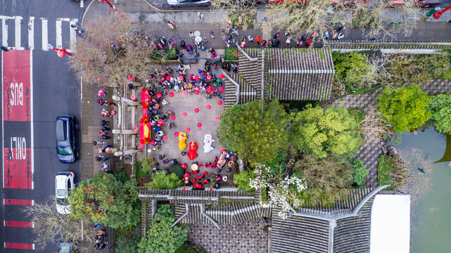 Aerial view of the Lan Su Chinese Garden during a lion dance performance with a crowd of people gathered in the courtyard and traditional tiled roofs Portland, Oregon, United States.
