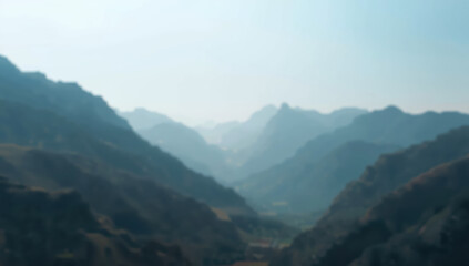 Fototapeta premium Soft softly blurred mountain valley with layered ridges and hazy blue atmosphere