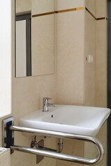 Fototapeta premium A sink is installed in a restroom with grab bars for support by users in need