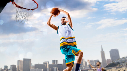 Basketball. Basketball player practice on a basketball court in the big city. A beautiful landscape is in the background. © 103tnn