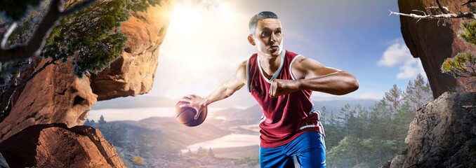 Basketball. A basketball player practices on a basketball court in the wilderness. A beautiful landscape is in the background. © 103tnn