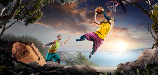 Basketball. Two basketball players practice on a basketball court in the wilderness. A beautiful landscape is in the background. © 103tnn