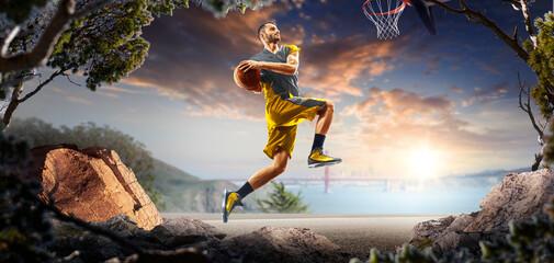 Basketball. A basketball player practices on a basketball court in the wilderness. A beautiful landscape is in the background. © 103tnn