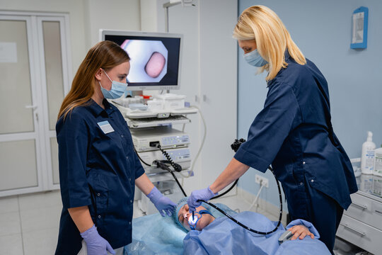 Endoscopic examination with doctors and female patient in hospital, gastroscopy bronchoscopy or ENT endoscopy procedure, modern medical equipment and healthcare concept
