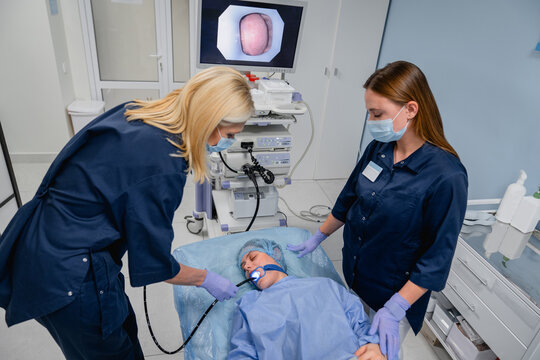 Woman patient and doctors during medical endoscopic examination in modern hospital, gastroscopy bronchoscopy or ENT endoscopy procedure, diagnostic healthcare concept