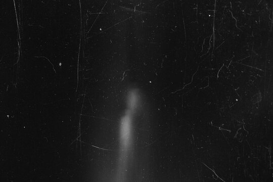 Black and white vintage film texture with heavy scratches and subtle light leak