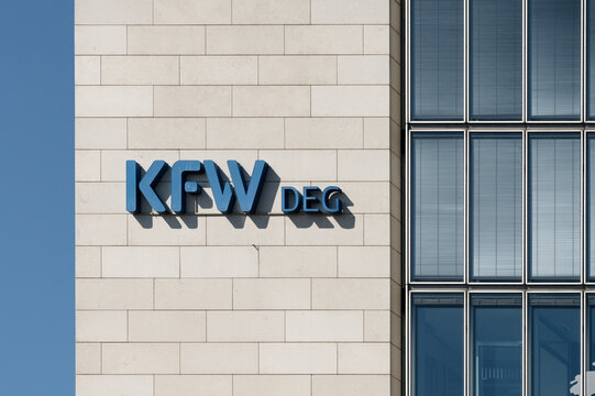 Cologne, Germany April 22 2026: Exterior view of the DEG headquarters in Cologne. Modern corporate design featuring the blue logo on a light stone facade and glass front in sunshine.