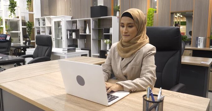 Muslim Women helpdesk call center use headphones talk to customer. Asian woman operator assistant customer service agent. Muslim Islam Businesswoman use laptop computer video call online meeting