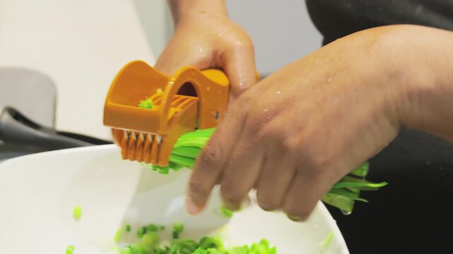 Black woman using a multi-blade scallion shredder for meal prep