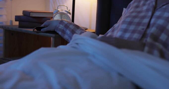 Woman taking sleeping mask from bedside table and going to sleep in bed at home, closeup