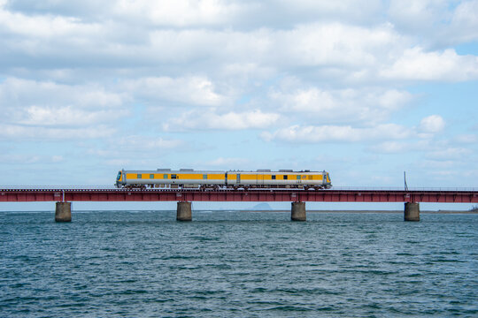 京都丹後鉄道の列車 由良川橋梁を渡る赤い車両と青い空(Red train of Kyoto Tango Railway crossing the Yuragawa Bridge under blue sky)
