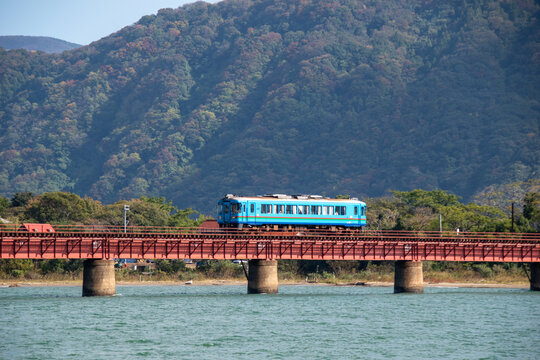 京都丹後鉄道の列車 由良川橋梁を渡る赤い車両と青い空(Red train of Kyoto Tango Railway crossing the Yuragawa Bridge under blue sky)