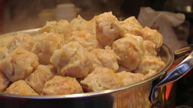 Close-up of steamed shumai dumplings in a pan, Asian street food and dim sum snack with savory filling and fresh homemade texture.