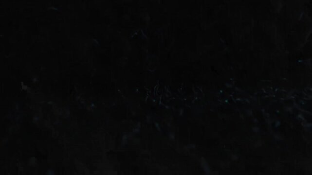 A very dark, almost black background with subtle, scattered specks of light and faint texture.