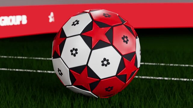 Spinning red soccer ball dropping onto turf as camera moving, bouncing, rolling to rest by hoarding