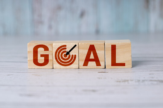 Wooden blocks or cubes that spell the word goal, the 'o' is a target or goalpost.