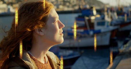 Basking woman facing warm harbor sun, brown jacket fleece, orange sweater, boats, light streaks © vectorfusionart