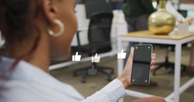 Holding woman checking smartphone at office with thumbs-up overlays, hoop earring, copy space