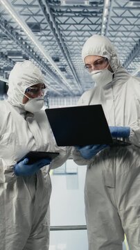 Vertical video Developing microchips, advanced electronics automation and EDA engineers in smart factory. Optimizing semiconductor design flow, simulation software and experts using devices, camera A