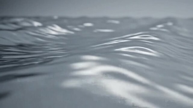 Close-up view of rippling water surface with soft light reflections and gentle waves.
