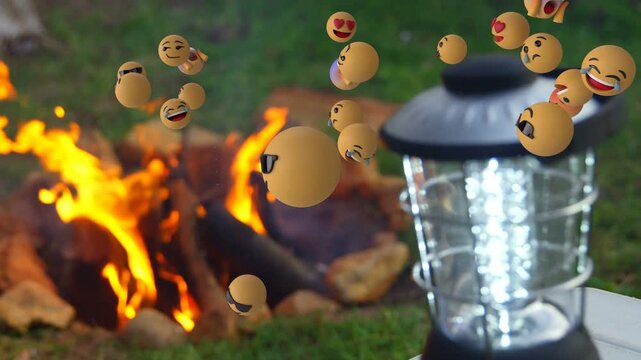 Portable LED lantern staying lit while emojis appearing from right, drifting left showing campfire